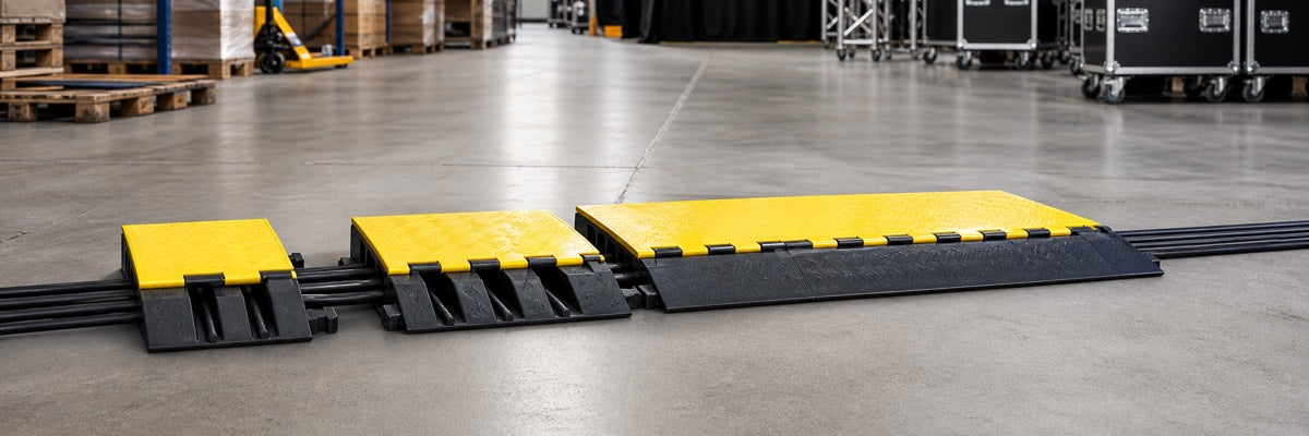 Modular black and yellow rubber cable protector ramps in a professional warehouse and event environment